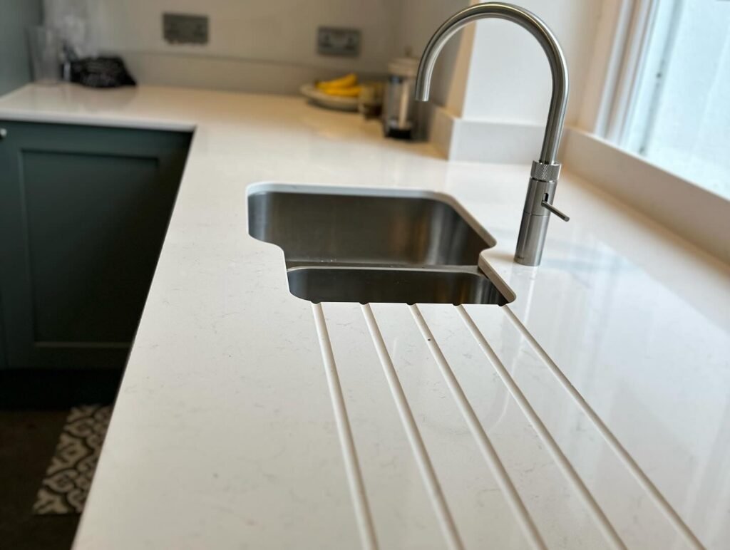 A close-up of seamless Quartz worktops in a custom kitchen installation by ProCut Carpentry in Peacehaven.