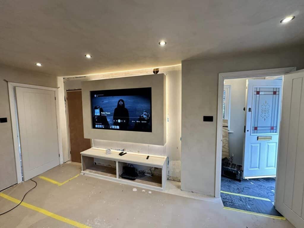 A sleek, custom media wall design with integrated storage installed by ProCut Carpentry in Burgess Hill