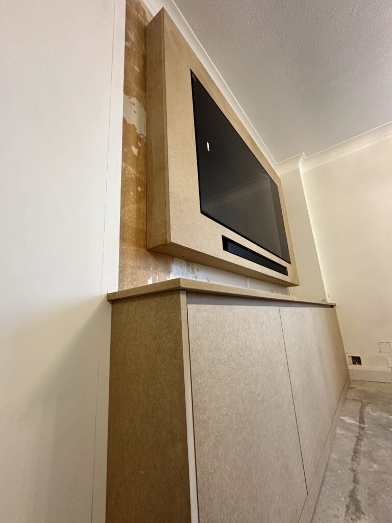 Handless storage incorporated into a bespoke media wall in Varndean