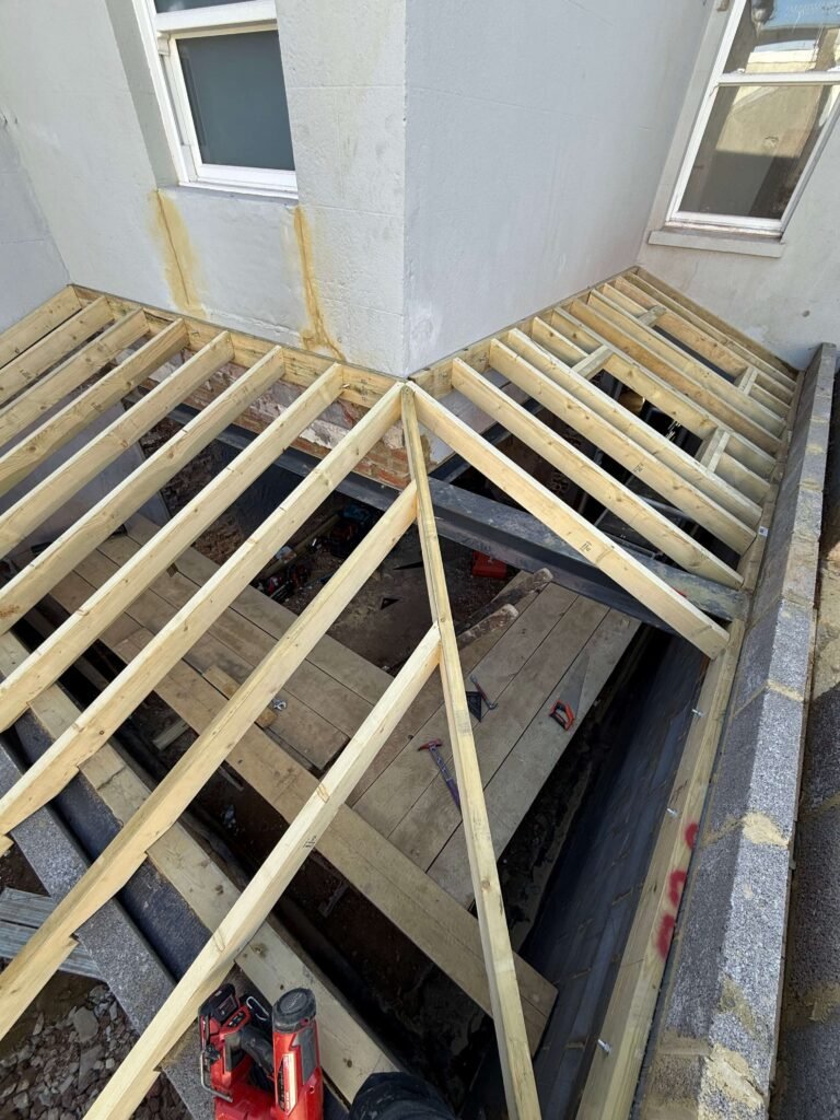 Traditional hand-cut roof carpentry showcasing craftsmanship in Hove refurbishment project.